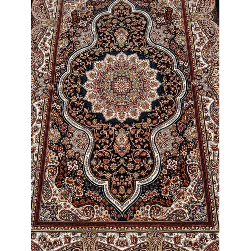 247 - A modern Persian style machine woven Elena rug, ornate design on a black ground, double guard border... 