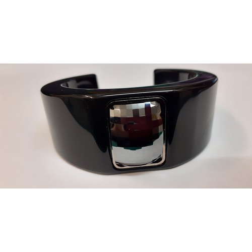 60 - Hugo boss- A modern black plastic bangle with central rectangular and faceted silver coloured decora... 