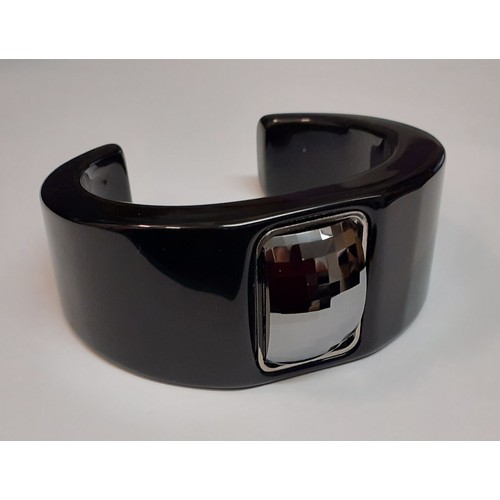 60 - Hugo boss- A modern black plastic bangle with central rectangular and faceted silver coloured decora... 