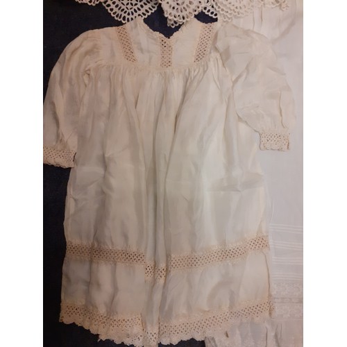 122 - Early 20th Century children's clothing to include white cotton christening dresses, a cream silk gir... 