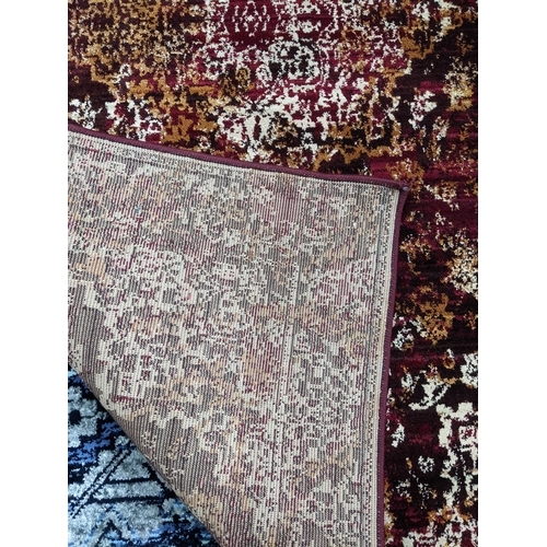 103 - A contemporary small floral patterned machine woven rug on a red ground 147cm x 92cm Location:G