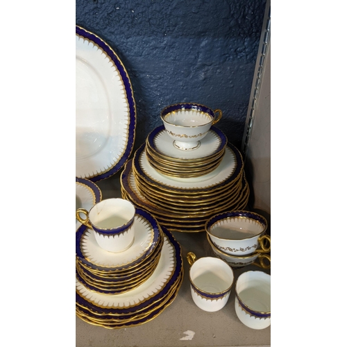 223 - An early 19th/20th century Coalport cobalt blue and white dinner service having gold coloured candle... 