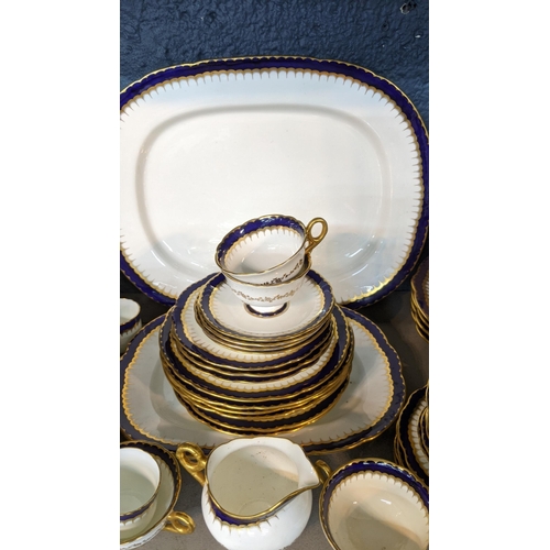 223 - An early 19th/20th century Coalport cobalt blue and white dinner service having gold coloured candle... 