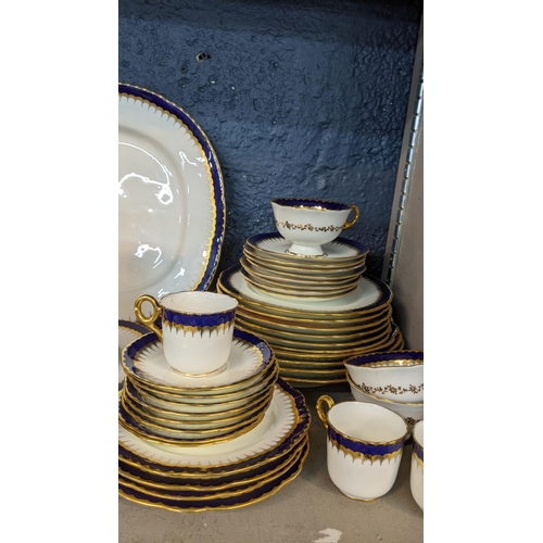 223 - An early 19th/20th century Coalport cobalt blue and white dinner service having gold coloured candle... 