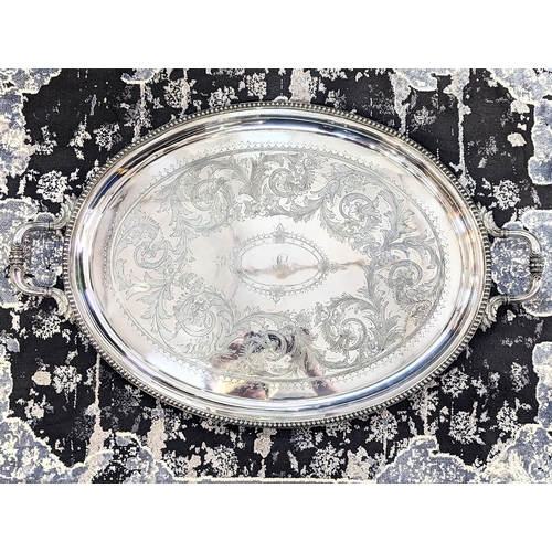 55 - A large twin handled oval silver plated serving tray, engraved with floral decoration and a central ... 