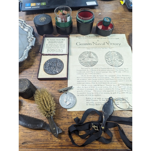 57 - A mixed lot to include silver plated food tray ladles and others along with a boxed Lusitania Medal,... 