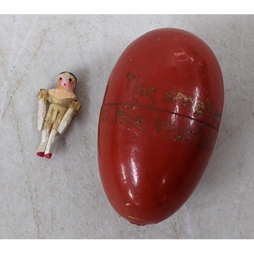 43 - A 19th century peg jointed wooden doll with egg shaped case inscribed ' The Smallest Doll in the Wor... 