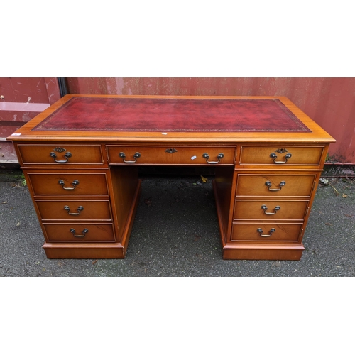 91 - A reproduction mahogany twin pedestal desk having a red leather top above nine drawers 79cm h x 152c... 