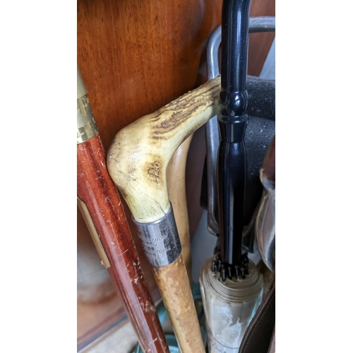 92 - A cast iron green painted stick stand, together with shooting sticks and walking sticks including a ... 