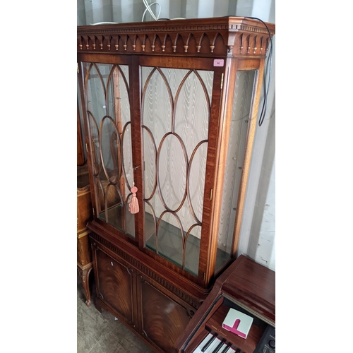 96 - A reproduction mahogany display cabinet having a dental moulded cornice above two glazed and two cup... 