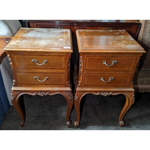 98 - A pair of reproduction French bedside tables having two drawers, floral carved decoration and on cab... 