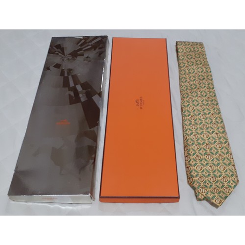 139 - Hermes- A silk tie in yellow having brown and green images of melons and melon segments in an iconic... 