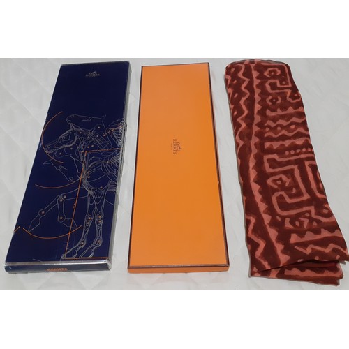 140 - Hermes- A fine silk chiffon wrap in rust and salmon colours, having large capital letters within the... 