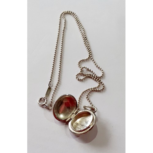 141 - Tiffany-A silver necklace having a ball chain and a small oval shaped locket with makers mark stampe... 