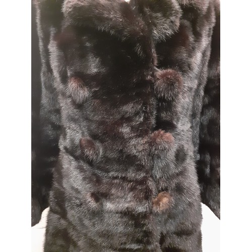 164 - A 1960's black mink knee-length coat having 6 fur covered buttons and a black silk lining with pleat... 