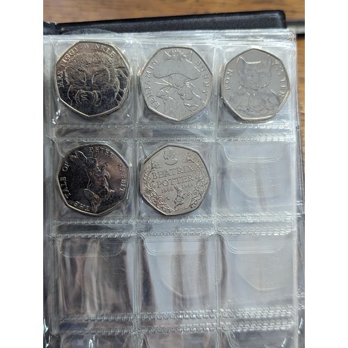 81 - An album of 20, 50p and one £2 coin to include a replica/re-strike 2009 Kew gardens 50p, London 2012... 