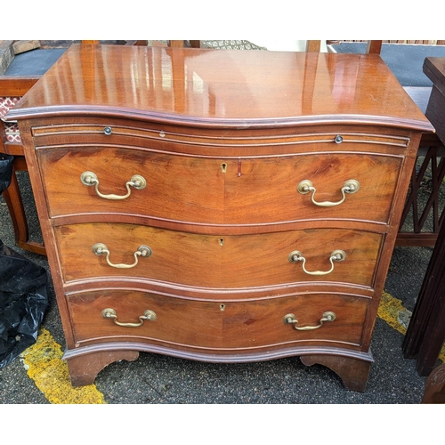 327 - A Georgian inspired mahogany serpentine fronted chest of three drawers having a brush slide and brac... 