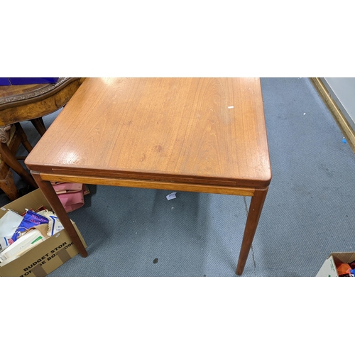 412 - A retro teak extending dining table with two extra leaves and on turned tapering legs, 72cm h x 165c... 