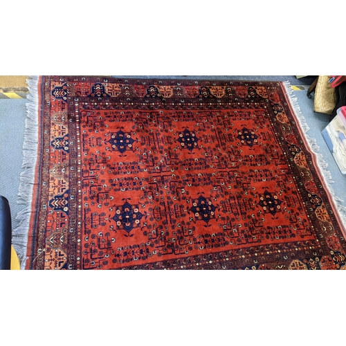 415 - A Persian hand woven rug having a floral design on a red ground and multi-guard borders, 162cm x 189... 