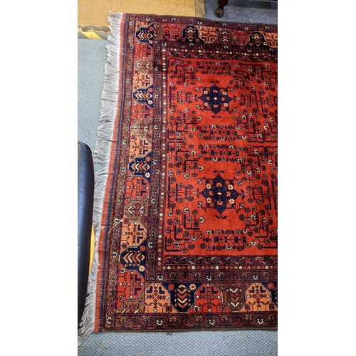 415 - A Persian hand woven rug having a floral design on a red ground and multi-guard borders, 162cm x 189... 