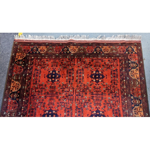 415 - A Persian hand woven rug having a floral design on a red ground and multi-guard borders, 162cm x 189... 