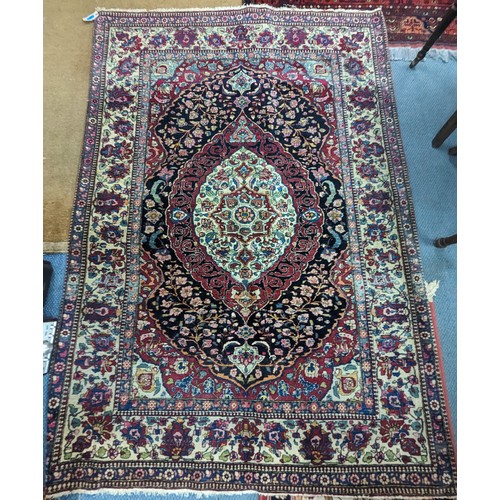 430 - A Persian hand woven red ground rug having central motif, floral multi-guard border, 144cm x 200cm
L... 