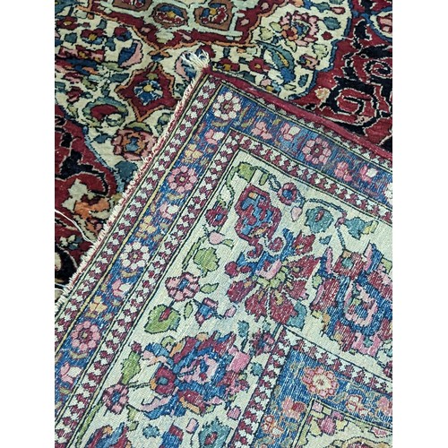 430 - A Persian hand woven red ground rug having central motif, floral multi-guard border, 144cm x 200cm
L... 