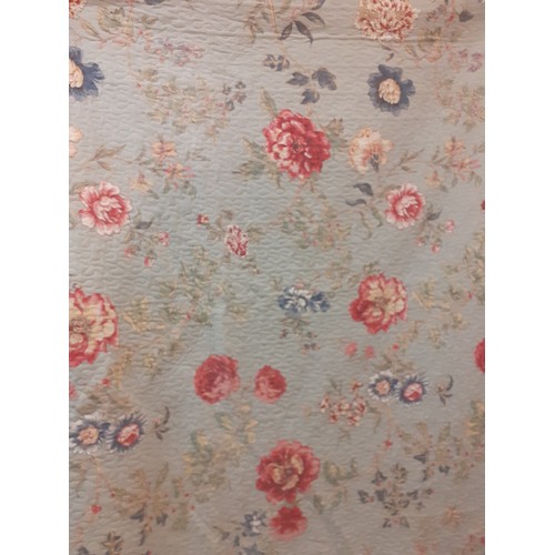 92 - A large American style bed cover having a green ground with swirls of flora and leaves in reds and b... 