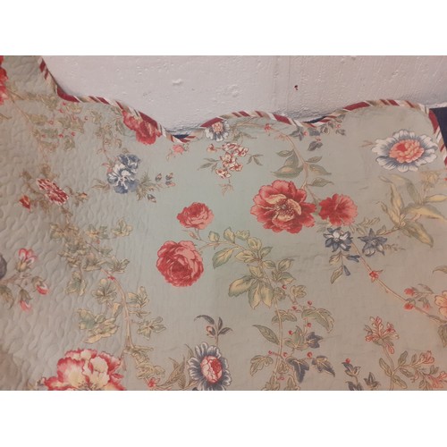 92 - A large American style bed cover having a green ground with swirls of flora and leaves in reds and b... 