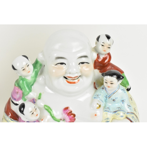 143 - A 20th century Chinese porcelain model of the laughing buddha, with five children around, decorated ... 