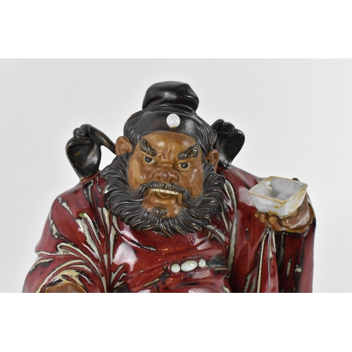 144 - A large 20th century Chinese shiwan glazed pottery model of Zhong Kui by Liu Zemian, in a seated pos... 