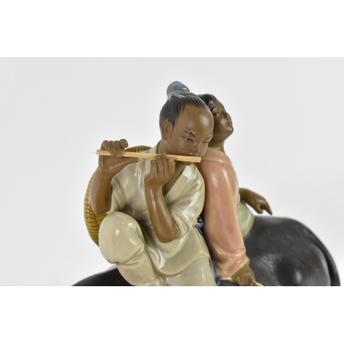 145 - A 20th century Chinese shiwan glazed pottery model of  by Liu Zemian, modelled as a couple on the ba... 