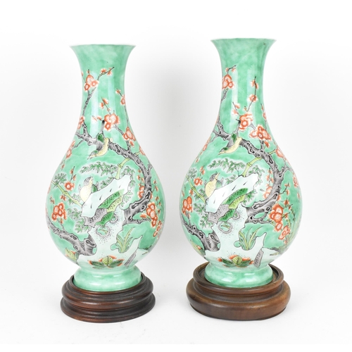 146 - A pair of 20th century Chinese enamelled baluster vases, each covered in a green enamel ground with ... 