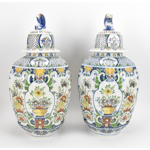 158 - A pair of early 20th century polychrome delft vases, with ribbed octagonal body, floral design carto... 