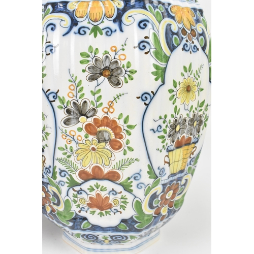 158 - A pair of early 20th century polychrome delft vases, with ribbed octagonal body, floral design carto... 