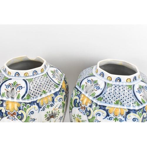 158 - A pair of early 20th century polychrome delft vases, with ribbed octagonal body, floral design carto... 