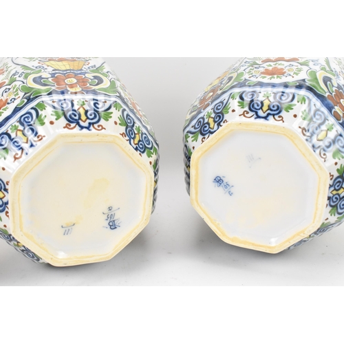 158 - A pair of early 20th century polychrome delft vases, with ribbed octagonal body, floral design carto... 