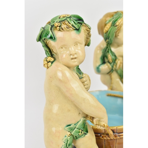 181 - A late 19th century Minton majolica centrepiece, circa 1858, modelled as two dyonisian cherubs carry... 