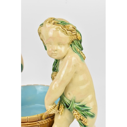 181 - A late 19th century Minton majolica centrepiece, circa 1858, modelled as two dyonisian cherubs carry... 