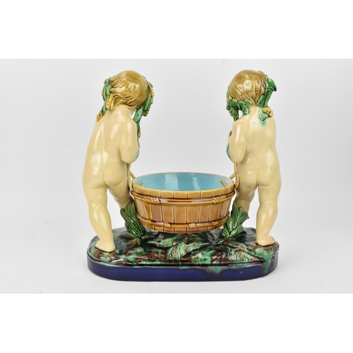 181 - A late 19th century Minton majolica centrepiece, circa 1858, modelled as two dyonisian cherubs carry... 