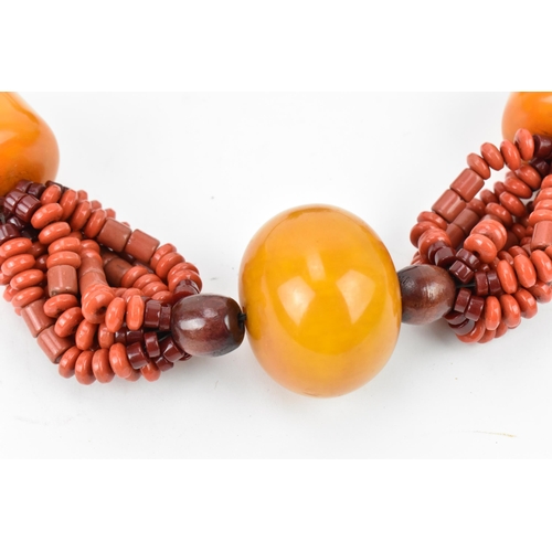 193 - A Moroccan Berber style pressed amber and coral bead necklace, with braided wool fastening, central ... 