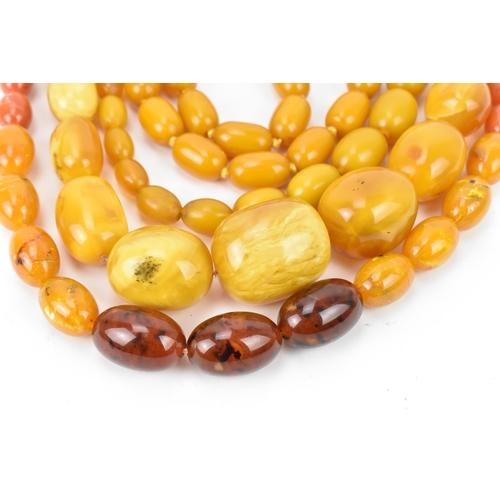 194 - A collection of pressed amber necklaces, with graduated beads, largest bead 4 cm wide