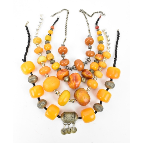 195 - A small group of Moroccan Berber style pressed amber and white metal necklaces