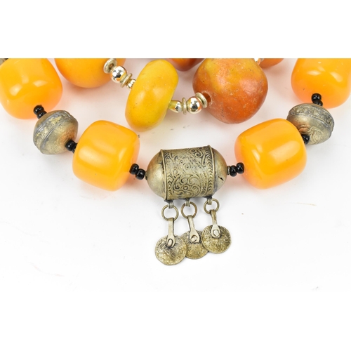 195 - A small group of Moroccan Berber style pressed amber and white metal necklaces