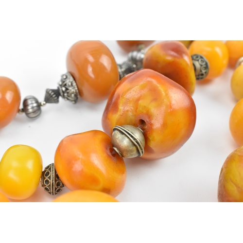 195 - A small group of Moroccan Berber style pressed amber and white metal necklaces