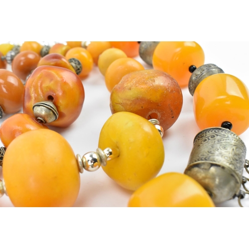 195 - A small group of Moroccan Berber style pressed amber and white metal necklaces