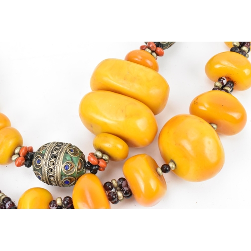 196 - Two Moroccan Berber style pressed amber and white metal, necklaces, one with coral, and enamel to th... 