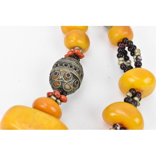 196 - Two Moroccan Berber style pressed amber and white metal, necklaces, one with coral, and enamel to th... 