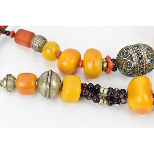 196 - Two Moroccan Berber style pressed amber and white metal, necklaces, one with coral, and enamel to th... 