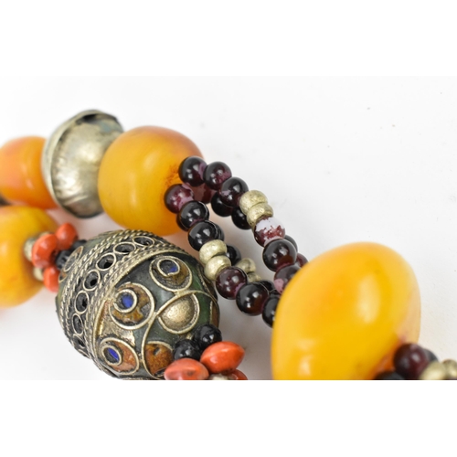 196 - Two Moroccan Berber style pressed amber and white metal, necklaces, one with coral, and enamel to th... 